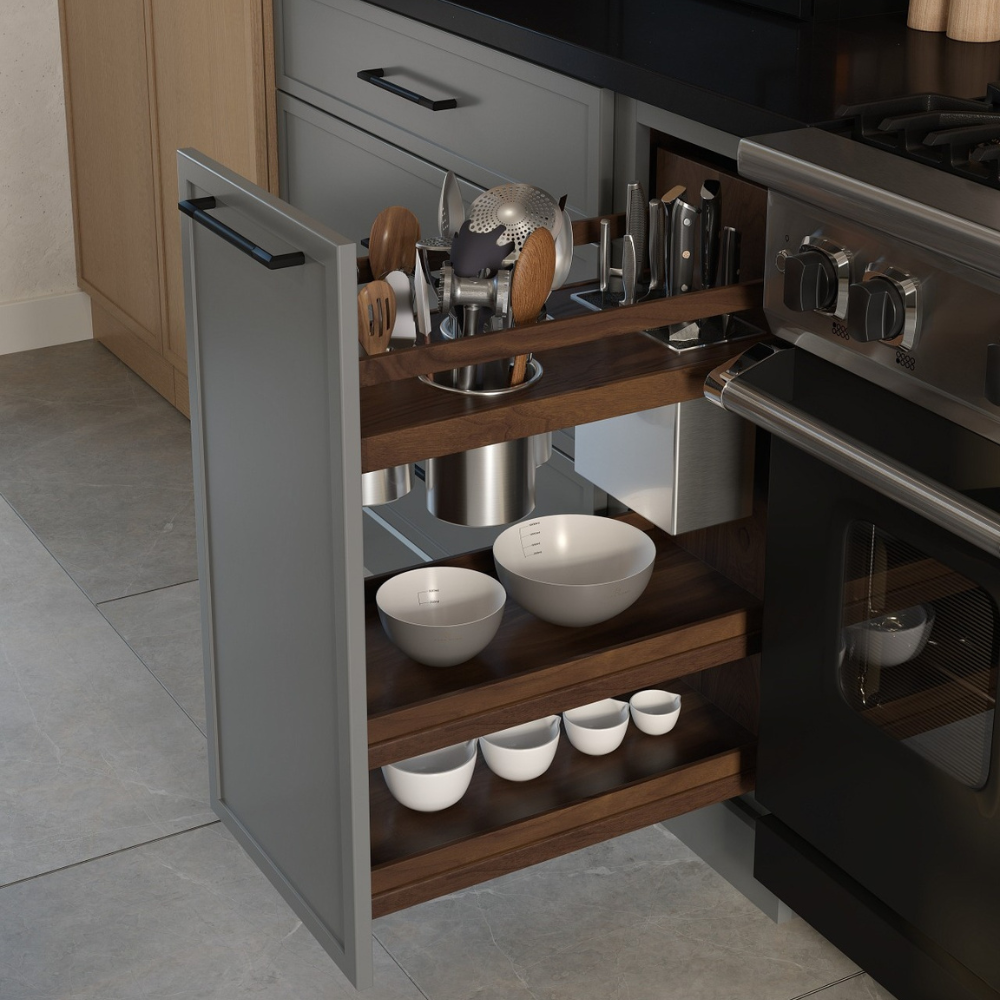 Contemporary kitchen with a pull-out cabinet storing utensils, bowls, and a knife block, next to a stainless steel range and dark countertop.